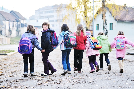 happy school girls running outdoor at sunny autumn day