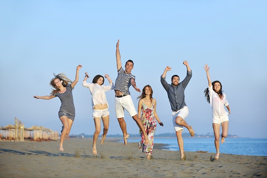 happy young people group have fun run and jump on beach beautiful sand beach