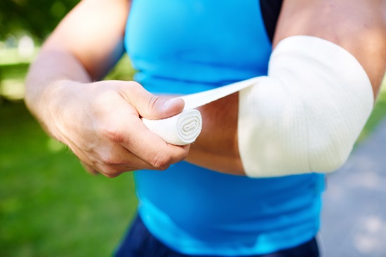 Close-up of male bandaging his arm